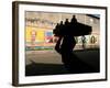 A Boy Carrying Bottles on His Head Passes by a Wall with Pictures of Haitian President Renel Preval-Ariana Cubillos-Framed Photographic Print