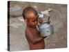 A Boy in a Slum Along the Yamuna River in the Older Part of New Delhi Drinks Water from a Tea Pot-null-Stretched Canvas