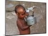 A Boy in a Slum Along the Yamuna River in the Older Part of New Delhi Drinks Water from a Tea Pot-null-Mounted Photographic Print