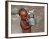 A Boy in a Slum Along the Yamuna River in the Older Part of New Delhi Drinks Water from a Tea Pot-null-Framed Photographic Print