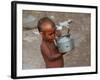 A Boy in a Slum Along the Yamuna River in the Older Part of New Delhi Drinks Water from a Tea Pot-null-Framed Photographic Print