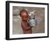 A Boy in a Slum Along the Yamuna River in the Older Part of New Delhi Drinks Water from a Tea Pot-null-Framed Photographic Print