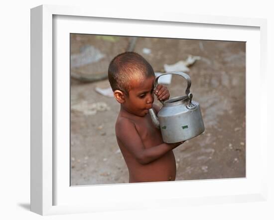 A Boy in a Slum Along the Yamuna River in the Older Part of New Delhi Drinks Water from a Tea Pot-null-Framed Photographic Print