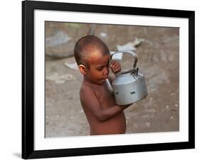A Boy in a Slum Along the Yamuna River in the Older Part of New Delhi Drinks Water from a Tea Pot-null-Framed Photographic Print