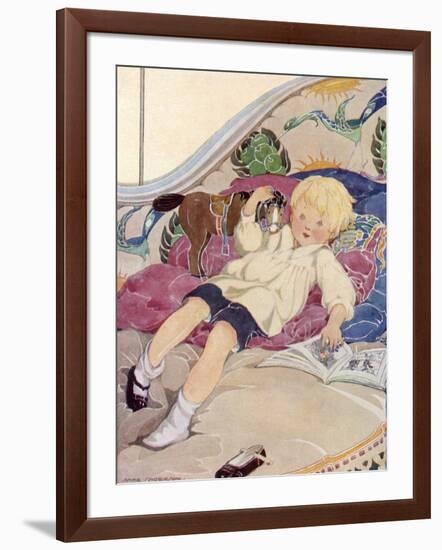 A Boy Lying on a Bed with a Book and a Toy Horse-Anne Anderson-Framed Art Print