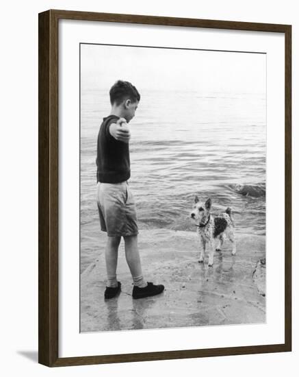 A Boy Throws Stones into the Sea for His Dog to Retrieve: the Dog Looks Up Expectantly-Henry Grant-Framed Photographic Print