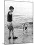 A Boy Throws Stones into the Sea for His Dog to Retrieve: the Dog Looks Up Expectantly-Henry Grant-Mounted Photographic Print