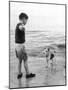 A Boy Throws Stones into the Sea for His Dog to Retrieve: the Dog Looks Up Expectantly-Henry Grant-Mounted Photographic Print