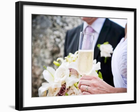 A Bride and Groom with a Glass of Champagne and a Bouquet-null-Framed Photographic Print