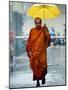 A Buddhist Monk Walks in the Rain on a Street in Bangkok-null-Mounted Photographic Print