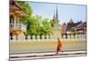 A buddhist monk walks past Wat Si Saket (Wat Sisaket) temple in central Vientiane, Laos-Jason Langley-Mounted Photographic Print