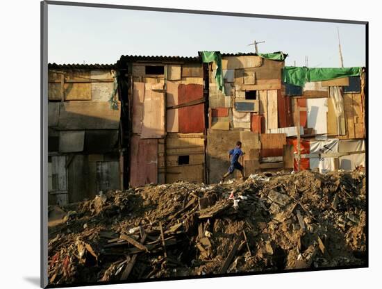 A Child Runs by a Row of Shacks in Novo Mundo Shantytown, Sao Paulo, Brazil-null-Mounted Photographic Print