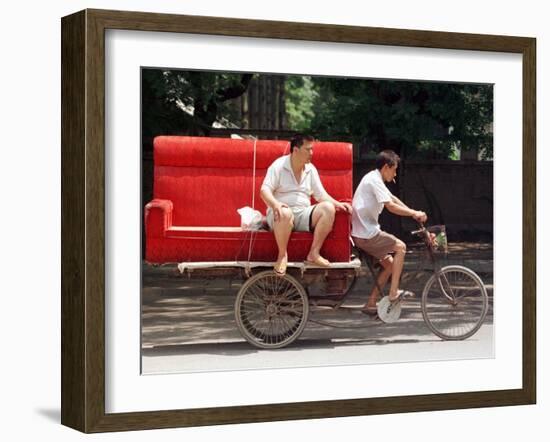 A Chinese Man Rides on a Sofa as Another Pedals a Delivery Tricycle-null-Framed Photographic Print