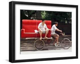 A Chinese Man Rides on a Sofa as Another Pedals a Delivery Tricycle-null-Framed Photographic Print