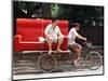 A Chinese Man Rides on a Sofa as Another Pedals a Delivery Tricycle-null-Mounted Photographic Print