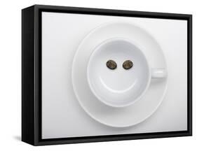A Coffee Cup with Two Coffee Beans Making a Smiley Face-Jean Gillis-Framed Stretched Canvas