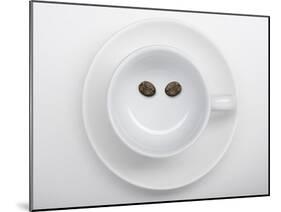 A Coffee Cup with Two Coffee Beans Making a Smiley Face-Jean Gillis-Mounted Photographic Print
