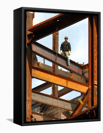 A Construction Worker Stands on a Steel Beam While Working on a High Rise Building-null-Framed Stretched Canvas