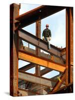 A Construction Worker Stands on a Steel Beam While Working on a High Rise Building-null-Stretched Canvas