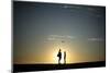 A Couple Stands on a Sand Bank as the Sun Sets in Venice, Los Angeles-Lucy Nicholson-Mounted Photographic Print