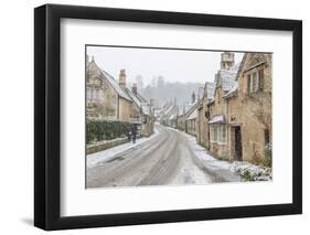 A couple walking up the hill in Castle Combe with an umbrella protecting them from the heavy snowfa-Paul Porter-Framed Photographic Print