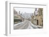 A couple walking up the hill in Castle Combe with an umbrella protecting them from the heavy snowfa-Paul Porter-Framed Photographic Print