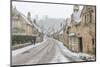 A couple walking up the hill in Castle Combe with an umbrella protecting them from the heavy snowfa-Paul Porter-Mounted Photographic Print