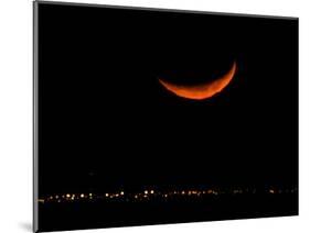 A Crescent Moon Dwarfs the Lights of Fort Riley Army Base in Central Kansas, January 22, 2007-Charlie Riedel-Mounted Photographic Print