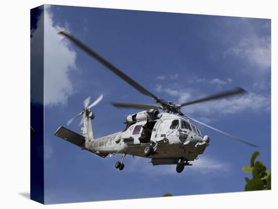 A Crew Chief Looks Out the Side Door of a Helicopter in Flight-null-Stretched Canvas