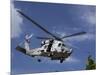 A Crew Chief Looks Out the Side Door of a Helicopter in Flight-null-Mounted Photographic Print