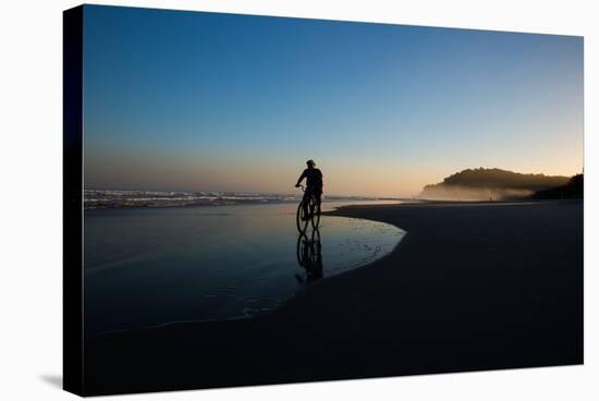 A Cyclist on Juquehy Beach at Sunset-Alex Saberi-Stretched Canvas