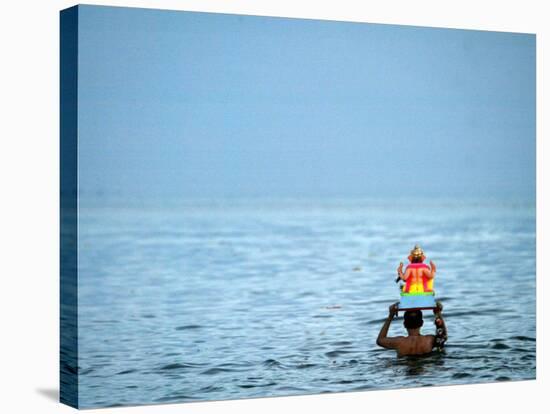 A Devotee Immerses the Idol of Elephant-Headed Hindu God Ganesh-null-Stretched Canvas