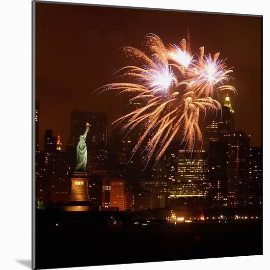 A Display of Fireworks Illuminates the Sky Near the Statue of Liberty-null-Mounted Photographic Print