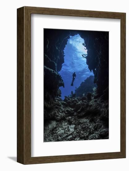 A diver stops at the entrance to an underwater cave in Grand Cayman, Cayman Islands-Stocktrek Images-Framed Photographic Print