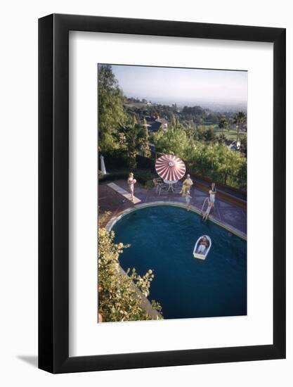 A Family at their Backyard Swimming Pool, in Foreground a Floating Rowboat with Boy Aboard-Frank Scherschel-Framed Photographic Print