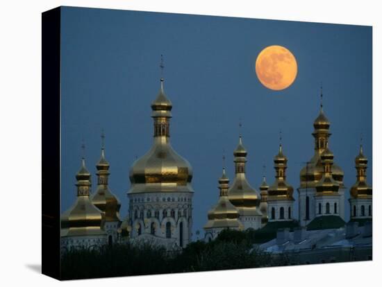 A Full Moon Rises in the Night Sky During a Lunar Eclipse-null-Stretched Canvas