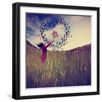 A Girl in a Field Tossing a Birdcage in the Air with Birds Flying in the Shape of a Heart Toned Wit-graphicphoto-Framed Photographic Print