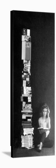 A Girl Reads Beside a Pile of Books-null-Stretched Canvas