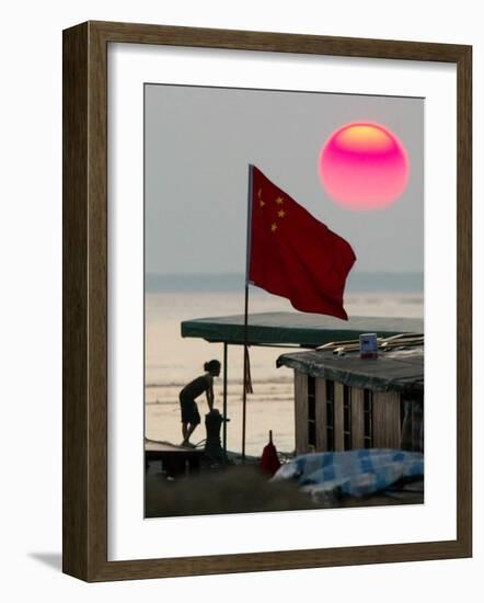 A Girl Rests on a Boat Below the Chinese National Flag-null-Framed Photographic Print