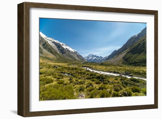 A glacier fed creek cuts through a green valley high in the mountains, South Island, New Zealand-Logan Brown-Framed Photographic Print