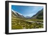 A glacier fed creek cuts through a green valley high in the mountains, South Island, New Zealand-Logan Brown-Framed Photographic Print