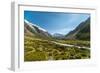 A glacier fed creek cuts through a green valley high in the mountains, South Island, New Zealand-Logan Brown-Framed Photographic Print