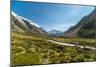 A glacier fed creek cuts through a green valley high in the mountains, South Island, New Zealand-Logan Brown-Mounted Photographic Print