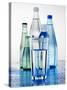 A Glass in Front of Mineral Water Bottles-Alexander Feig-Stretched Canvas
