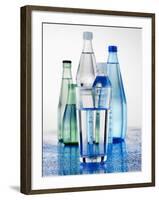 A Glass in Front of Mineral Water Bottles-Alexander Feig-Framed Photographic Print