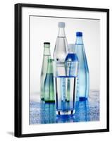 A Glass in Front of Mineral Water Bottles-Alexander Feig-Framed Photographic Print