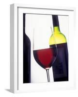 A Glass of Red Wine with a Bottle in the Background-Armin Faber-Framed Photographic Print