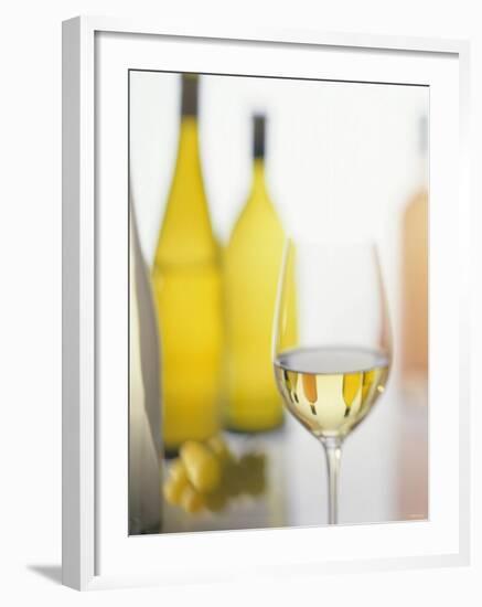 A Glass of White Wine and Wine Bottles in Background-Ulrike Koeb-Framed Photographic Print