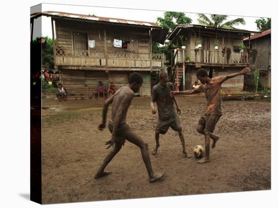 A Group of Panamanian Youths Slide Through the Mud During a Pick-Up Game of Soccer-null-Stretched Canvas