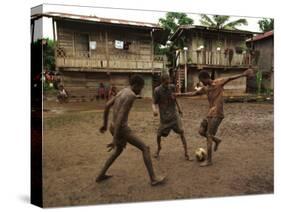 A Group of Panamanian Youths Slide Through the Mud During a Pick-Up Game of Soccer-null-Stretched Canvas